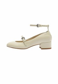Zapato de cuero blanco con tacón cuadrado, punta redondeada, correa en el tobillo y hebilla decorativa. Textura suave y diseño sencillo.