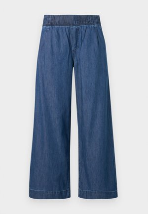 Pantalon en jean bleu à jambes larges avec taille élastique et coutures avant subtiles sur un fond uni.