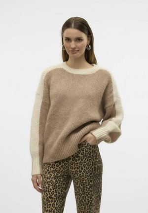 Pull en tricot beige avec des manches en crème, doté d'un col rond. Assorti avec un pantalon moulant imprimé léopard.