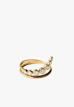 Anillo de oro con diseño de doble banda y siete piedras preciosas transparentes, redondas y engastadas en bisel, dispuestas en tamaño ascendente.