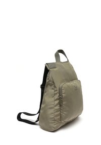 Beige nylonselkkäri, jossa on etupuolen vetoketjupokkari, pehmustetut hihnat ja yläkantokahva. Silkkinen pinta ja minimalistinen muotoilu.