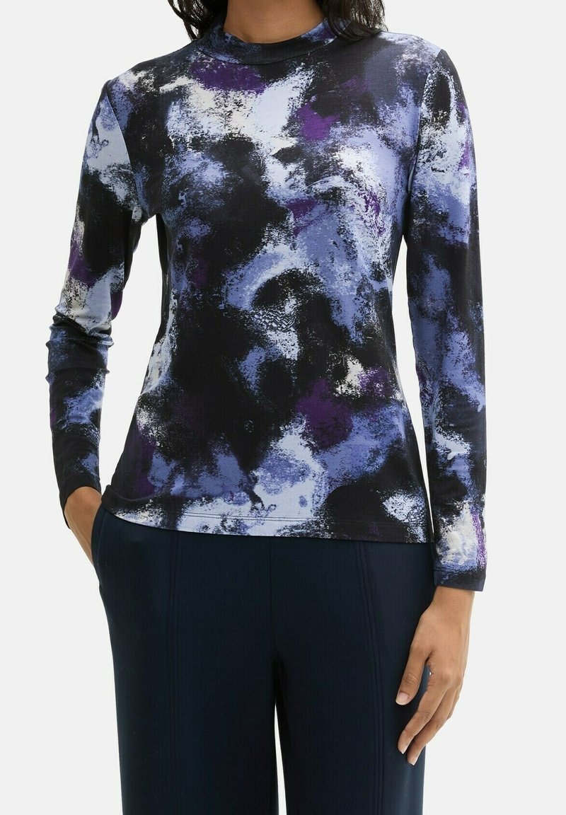 Halenka s dlouhým rukávem z měkké tkaniny s černým, fialovým a modrým abstraktním vzorem. Vyšší límec, přiléhavý střih a bezšvové manžety.