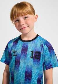 Blå och lila randig tröja med texturerad yta, med siffran 12 och en logotyp på vänster sida. Korta ärmar och svart krage.