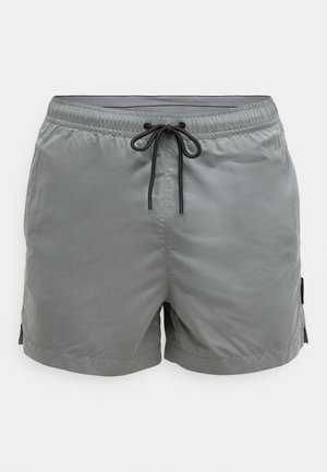 Sive muške kupaće hlače s elastičnim pojasom, podesivim vezicama i bočnim džepovima. Izrađene od glatkog, laganog materijala.