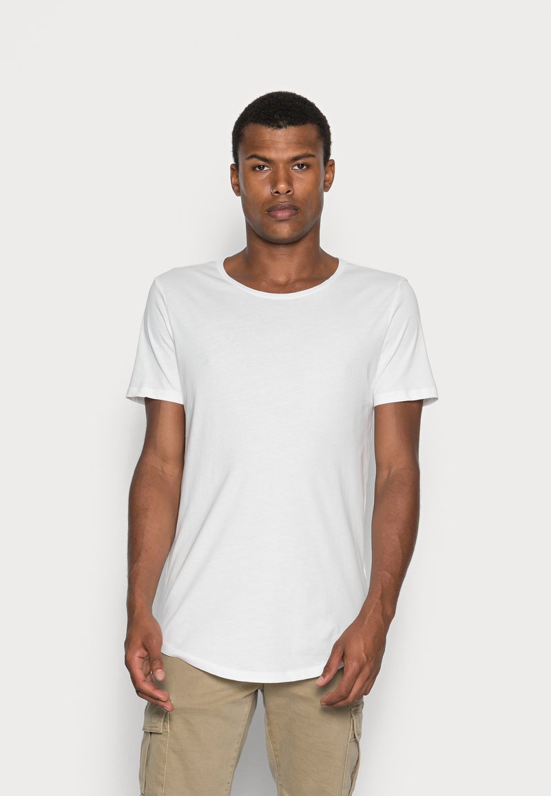 Weißes Baumwoll-T-Shirt mit Rundhalsausschnitt, kurzen Ärmeln und abgerundetem Saum. Glatte Textur, lockere Passform, geeignet für lässige Kleidung.