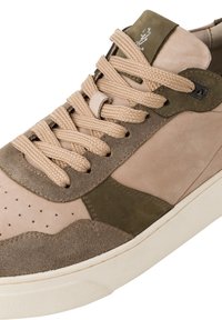 Sneaker din piele de culoare bronz și verde măsliniu, cu detalii perforate, șireturi groase și o talpă texturată. Prezintă secțiuni din suede și secțiuni netede.