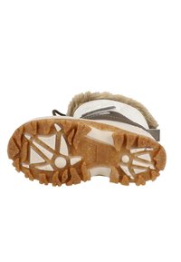 Stiefelsohle aus Gummi mit einem robusten, strukturierten Muster, in einer braun-weißen Farbgestaltung und mit einem Fellrand am oberen Rand.