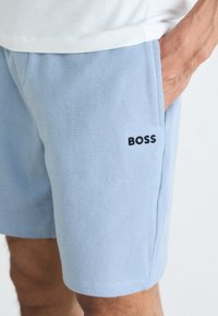 Lichtblauwe shorts van gestructureerde stof, met het zwarte 'BOSS' logo aan de linkerkant, ontworpen met zakken en een ontspannen pasvorm.