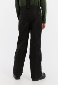 Zwarte waterdichte sneeuwbroek met verstelbare banden, ruime pasvorm, gemaakt van duurzaam materiaal, met een gladde textuur en licht reflecterende details.