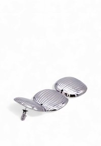 Spilla in metallo color argento con design a forma di conchiglia, texture rigata, tre conchiglie interconnesse e chiusura a spilla sicura.