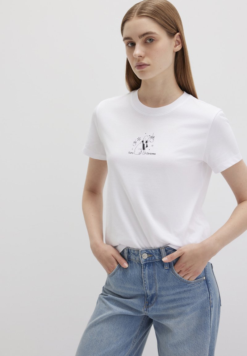 Weißes Baumwoll-T-Shirt mit rundem Ausschnitt und kurzen Ärmeln, mit einem bedruckten Design eines Hundes und Blumenakzenten auf der Vorderseite.