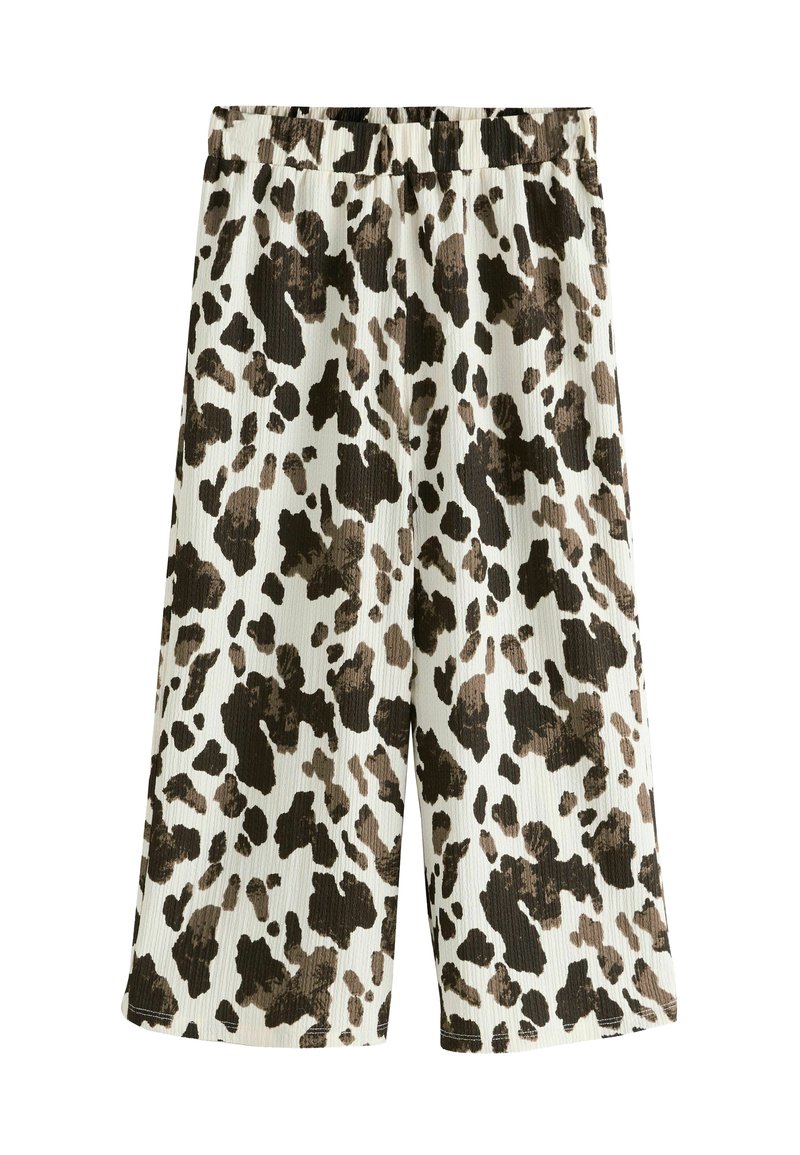 Culotte-shorts med ribbet tekstur, elastisk talje og en cremefarvet bund med et brunt og sort cow-print mønster.