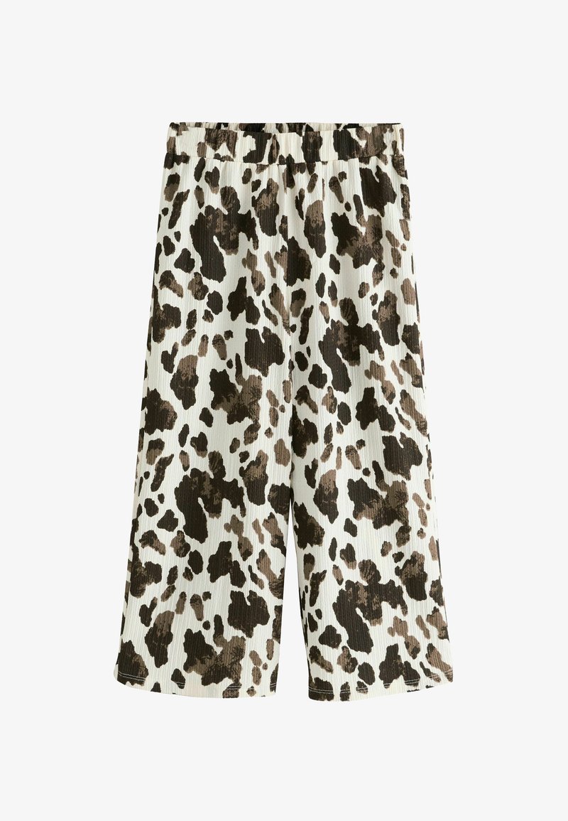 Pantaloni culotte con una texture a coste, vita elastica, e una base color crema con un motivo a macchie di mucca marroni e nere.