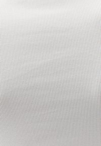 Biała bawełniana tkanina z subtelnymi pionowymi paskami, lekko teksturowana, gładkie wykończenie, elastyczny i miękki wygląd, bez widocznych wzorów ani detali.