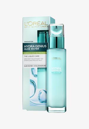 La bouteille Hydra Genius Aloe Water présente un design en turquoise gelé et élégant avec un capuchon à pompe. La boîte affiche le nom du produit et les principaux ingrédients en lettres capitales.