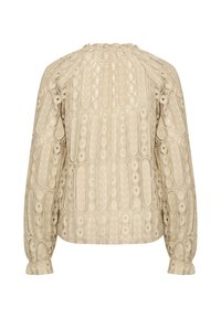 Beige blouse with intricate embroidered patterns, puffed sleeves, and a round neckline. Textured fabric with decorative details throughout.