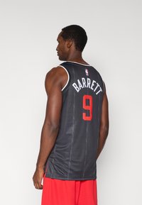 Čierny basketbalový dres s bielymi akcentmi, s nápisom „BARRETT“ a číslom „9“ v červenej farbe. Vyrobený z textúrovanej látky, zobrazený na mužskom modeli.