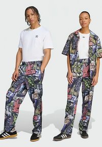 Vitt bomull T-shirt med korta ärmar, svart logotyp. Färgglada mönstrade byxor och skjorta med grafik, tillverkade av lätt material.