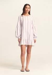Abito a righe bianco con strisce rosa e blu, maniche a sbuffo lunghe, scollatura tonda e orlo arricciato. Tessuto leggero.
