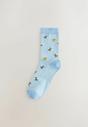 Világoskék pamutzokni csíkos mintával, rajta rajzfilmszerű méhecskék és mézes bödönök. Bordás szegély és sima orr a kényelemért.