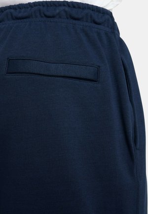 Pantalones de chándal azul marino con cintura elástica, que cuentan con un sencillo bolsillo trasero y un tejido suave y texturizado.