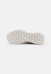 Suola di sneaker viola chiaro con una base in gomma bianca testurizzata, caratterizzata da scanalature decorative per una maggiore aderenza e una forma della punta arrotondata.