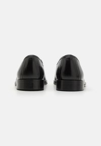 Black leather shoes with a smooth finish, flat heel, and rounded toes. No visible embellishments. Simple design with classic silhouette.