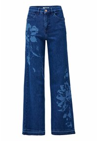 Jeans anchos de color azul con cintura alta y estampados florales desvaídos en el muslo izquierdo y la pantorrilla derecha, con botón frontal y lazos para cinturón.