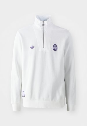 White pullover with a high collar, half-zip closure, embroidered purple logos, and ribbed cuffs. Soft texture, sport-inspired design.