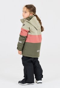 Chaqueta de invierno para niños hecha de material impermeable, con un diseño en bloques de color en verde oliva, rosa y gris, con capucha y detalles reflectantes.