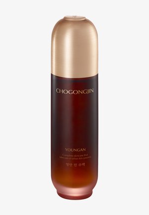Hohe zylindrische Hautpflegeflasche mit bernsteinfarbenem Farbverlauf und goldenem Deckel, beschriftet mit CHOGONGJIN YOUNGAN, zur Behandlung verschiedener Hautprobleme.