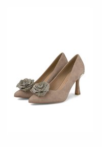 Scarpe beige in suede con tacco alto, punta affusolata e decorazioni a forma di rosa in perline argentate sul davanti. Tacchi bassi e a blocco.