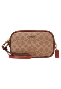 Sac bandoulière en tissu beige avec logo Coach, garniture incurvée en cuir marron et sangle réglable. Présente un motif subtil et une étiquette suspendue.