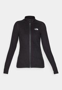 Zwarte fleecejack met lange mouwen, hoge kraag, volledige rits aan de voorkant, twee ritssluitingen in de zijzakken en een wit logo op de linkerborst.