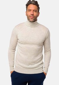 Helles beiges Rollkragenpullover aus weichem Material, mit einer taillierten Passform, langen Ärmeln sowie gerippten Bündchen und Saum.