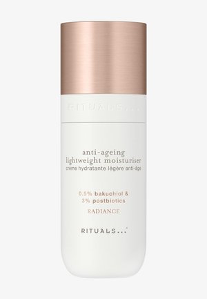 Anti-Aging leichte Feuchtigkeitscreme Flasche mit roségoldenem Deckel, beschriftet mit 0,5 % Bakuchiol, 3 % Postbiotika, Radiance von Rituals.