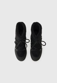 Scarpe alte nere con tomaia in tessuto peloso, suole in gomma e lacci neri. Le caratteristiche includono una finitura testurizzata e dettagli in metallo.