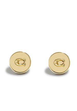 Set van twee ronde oorstekers in goudkleur met verheven letter "C" op elk, afgebeeld op een witte achtergrond.