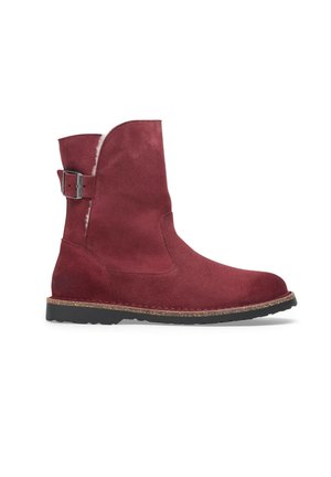 Bordeauxsuede enkellaars met een ronde neus, zijsluiting en een getextureerde rubberen zool voor verbeterde grip.
