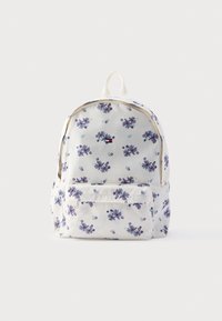 Σακίδιο πλάτης με λουλουδάτο μοτίβο σε κρεμ ύφασμα, διακοσμημένο με μοβ και τιρκουάζ λουλούδια, με τσέπη μπροστά και επάνω χερούλι καθώς και δύο ιμάντες ώμου.