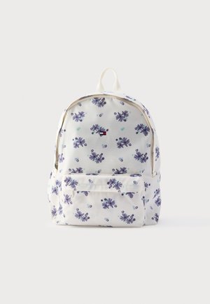 Rugzak met bloemenpatroon in crèmekleurige stof, met paarse en teal bloemen, een voorvak en een handvat bovenop met twee schouderbanden.