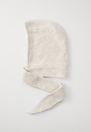 Knitted beige hat with tied, elongated sides. Features a ribbed texture and a soft, flexible material. Ideal for warmth and comfort.