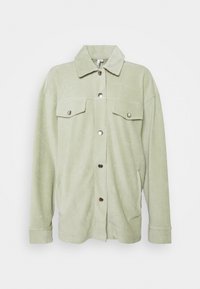 Giacca in corduroy verde chiaro con colletto, tasche frontali e bottoni metallici. Tessuto morbido con motivo a coste verticali. Fit regolare.