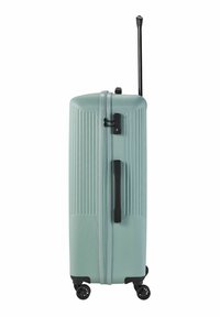Valise rigide de couleur vert menthe, avec une texture rainurée, une poignée rétractable noire, une serrure à combinaison, et quatre roues pivotantes.