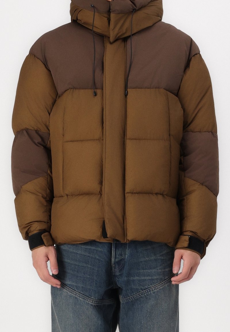 Braun und dunkelbraune Steppjacke mit Kapuze, ausgestattet mit einem gesteppeten Design, Zugbandverschluss und elastischen Bündchen.