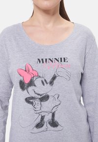 Maglietta grigia a maniche lunghe con un'illustrazione nera e rosa di Minnie Mouse con un fiocco rosa, scollo rotondo e texture morbida.