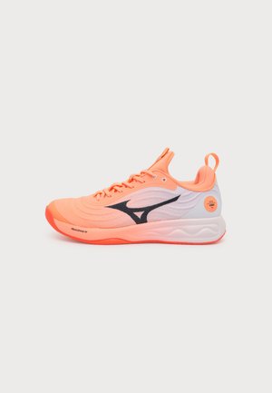 Orange og hvid sportssko med sort logo, snøredesign, tekstureret sål og trækfane ved hælen, vist på en ensfarvet hvid baggrund.