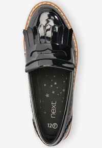 Zwarte gepatineerde leren instapper met een decoratieve franje, ronde neus en platte zool. De binnenkant heeft een sterpatroon stofvoering en een merklabel.