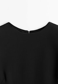 Tissu noir avec un col rond et une fermeture éclair centrée à l'arrière du col d'un vêtement.