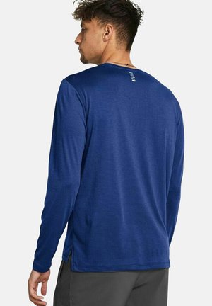 Camisa de manga larga azul marino hecha de un tejido texturizado, con cuello redondo, aberturas laterales y un detalle de logo en la parte alta de la espalda.